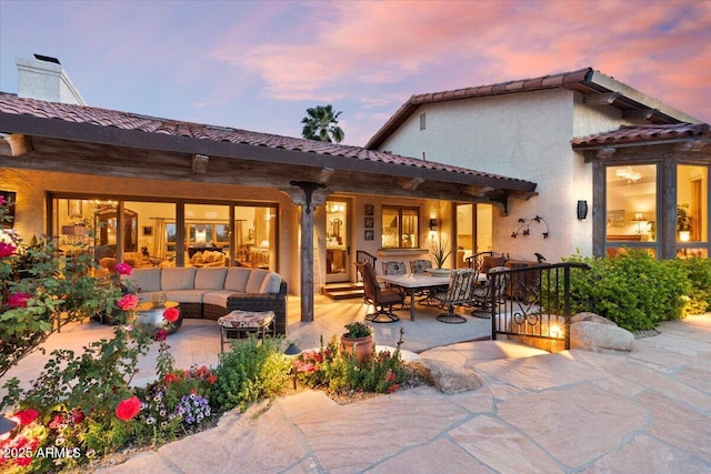 8514 E Country Club Trl, Scottsdale, AZ 85255 - back of property at dusk with an outdoor hangout area, a patio area, stucco siding, and a tile roof