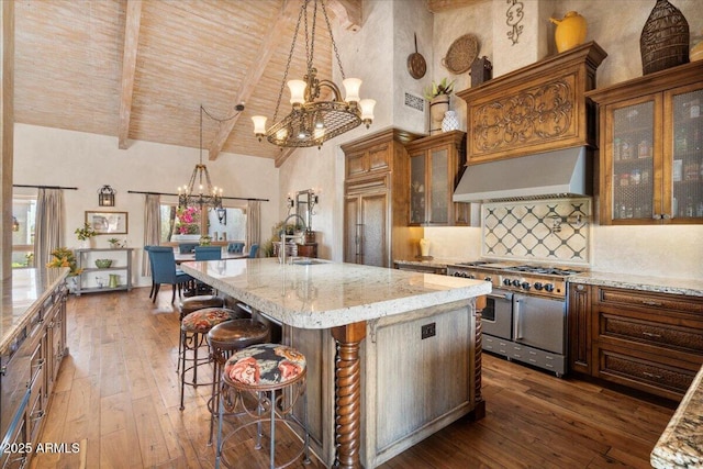 8514 E Country Club Trl, Scottsdale, AZ 85255 - kitchen with range with two ovens, a chandelier, custom exhaust hood, high vaulted ceiling, and dark wood finished floors