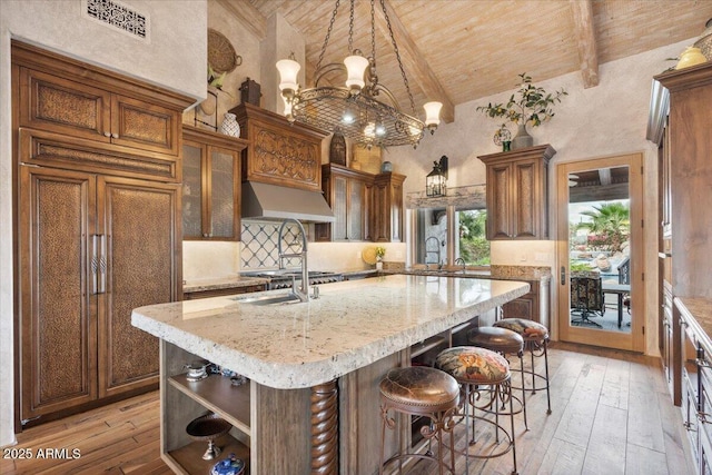 8514 E Country Club Trl, Scottsdale, AZ 85255 - kitchen with wood ceiling, high vaulted ceiling, light wood finished floors, an island with sink, and beamed ceiling