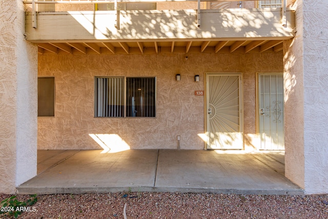 view of exterior entry with a balcony and a patio area