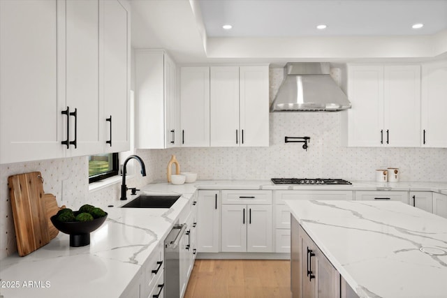 5919 N 45th St, Phoenix, AZ 85018 - kitchen with wall chimney range hood, appliances with stainless steel finishes, white cabinetry, light wood-style floors, and recessed lighting