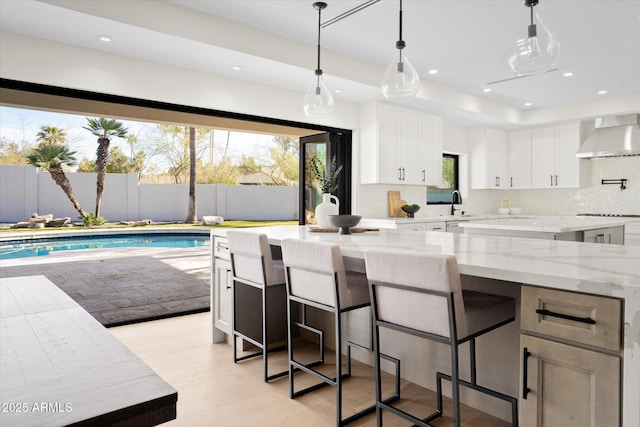 5919 N 45th St, Phoenix, AZ 85018 - kitchen with white cabinets, plenty of natural light, light stone counters, wall chimney range hood, and recessed lighting