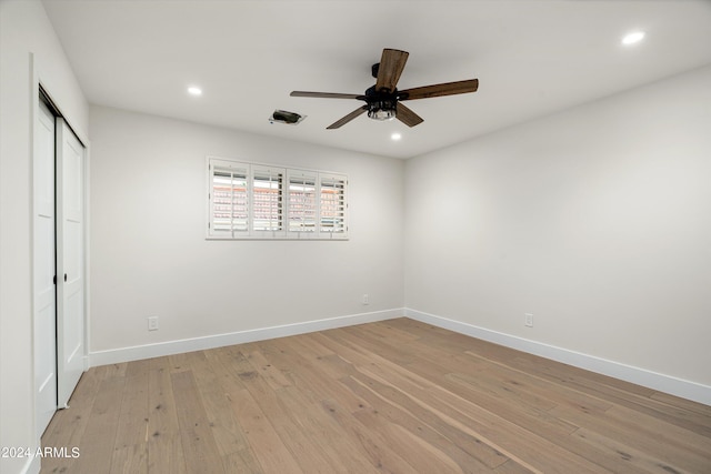 unfurnished bedroom featuring ceiling fan, light hardwood / wood-style floors, and a closet