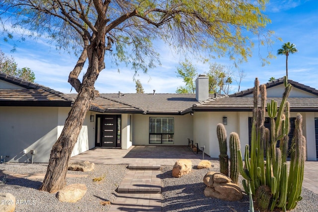 5919 N 45th St, Phoenix, AZ 85018 - view of front facade featuring a chimney, stucco siding, a tiled roof, and a patio