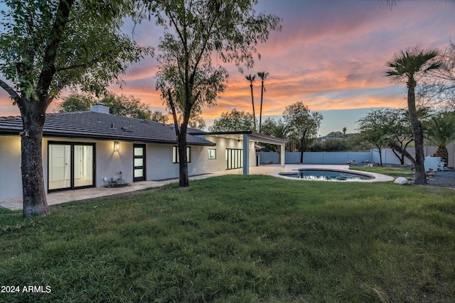 exterior space featuring a fenced in pool, a patio, and a lawn