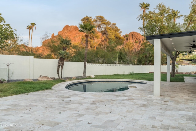 view of pool with ceiling fan, a mountain view, and a patio area