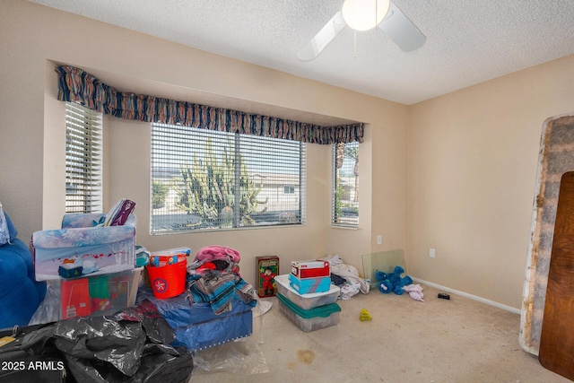 rec room with ceiling fan and a textured ceiling