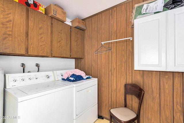 clothes washing area with cabinets and independent washer and dryer