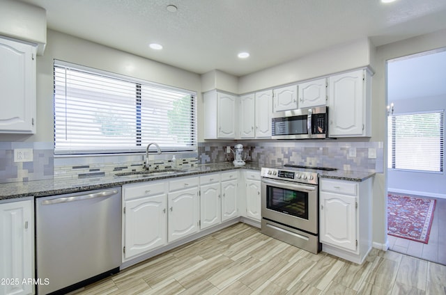 3921 W Jasper Dr, Chandler, AZ 85226 - kitchen with stainless steel appliances, a sink, dark stone counters, white cabinetry, and recessed lighting
