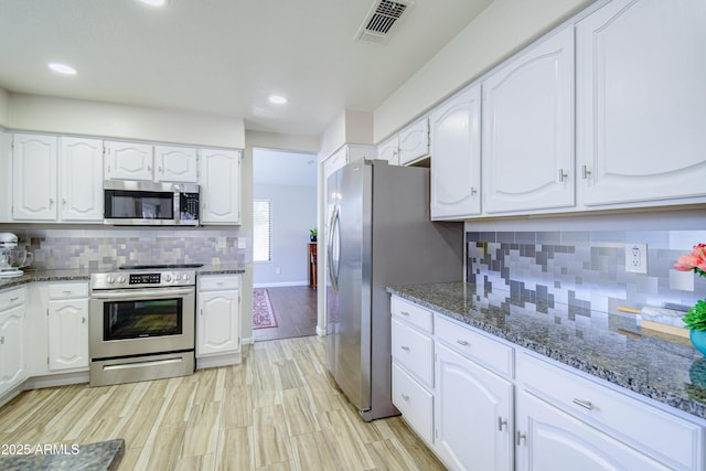3921 W Jasper Dr, Chandler, AZ 85226 - kitchen featuring appliances with stainless steel finishes, dark stone countertops, white cabinetry, and recessed lighting