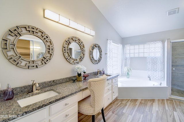 3921 W Jasper Dr, Chandler, AZ 85226 - bathroom with vaulted ceiling, double vanity, a garden tub, and a shower