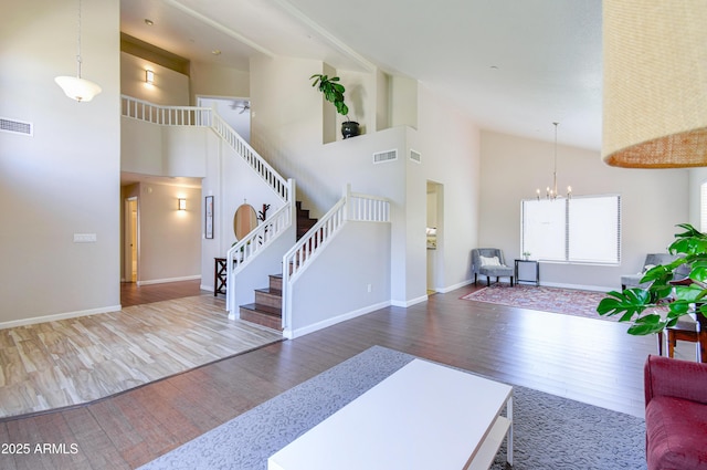 3921 W Jasper Dr, Chandler, AZ 85226 - living room featuring wood finished floors, high vaulted ceiling, a chandelier, stairs, and baseboards
