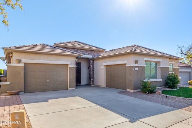 prairie-style house with an attached garage, driveway, and stucco siding