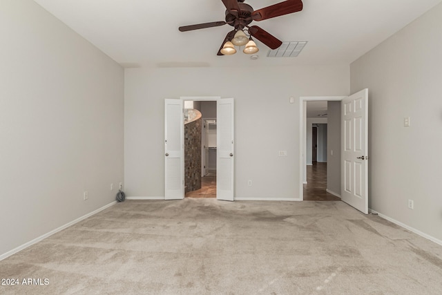 unfurnished bedroom featuring carpet floors, baseboards, visible vents, and a ceiling fan