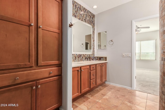 full bathroom featuring baseboards, double vanity, and tile patterned floors