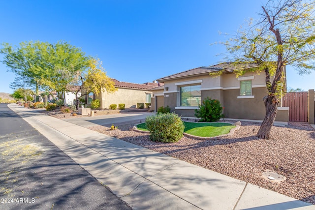 view of front of property featuring concrete driveway, fence, and stucco siding