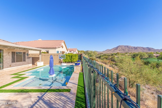 view of pool featuring a fenced in pool, a fenced backyard, a mountain view, and a patio