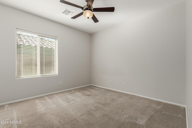 spare room featuring a ceiling fan, visible vents, light carpet, and baseboards