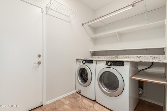 laundry room featuring laundry area, washing machine and clothes dryer, and baseboards