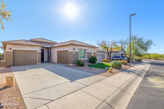 prairie-style house featuring an attached garage, concrete driveway, and stucco siding