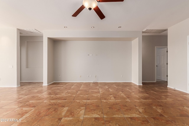 empty room featuring visible vents, a ceiling fan, and baseboards