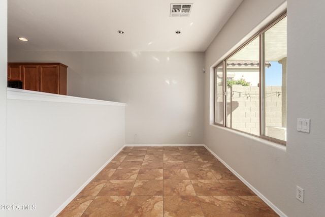 spare room with recessed lighting, visible vents, and baseboards