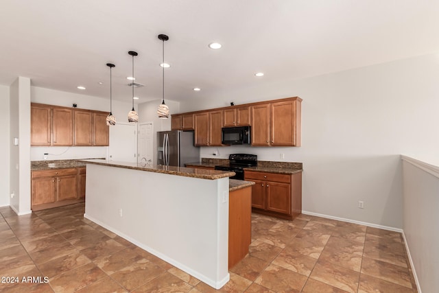 kitchen featuring recessed lighting, brown cabinetry, a kitchen island with sink, dark stone countertops, and black appliances