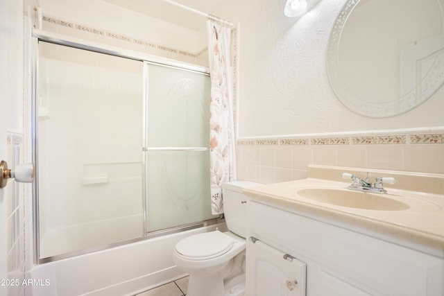 301 Whitton St, Sierra Vista, AZ 85635 - bathroom featuring vanity, tile walls, a wainscoted wall, enclosed tub / shower combo, and toilet