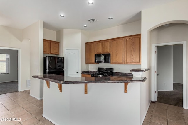 16846 N 49th Way, Scottsdale, AZ 85254 - kitchen featuring black appliances, a kitchen breakfast bar, light tile patterned floors, brown cabinetry, and recessed lighting