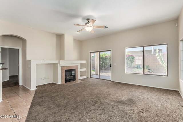 16846 N 49th Way, Scottsdale, AZ 85254 - unfurnished living room with ceiling fan, a tile fireplace, light carpet, light tile patterned floors, and baseboards