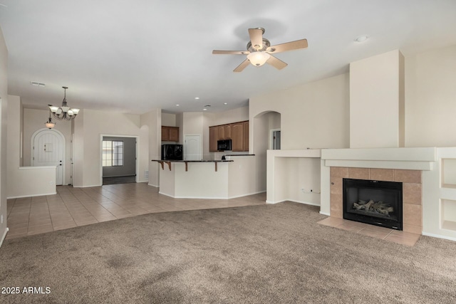 16846 N 49th Way, Scottsdale, AZ 85254 - unfurnished living room featuring light carpet, light tile patterned flooring, a chandelier, ceiling fan, and arched walkways