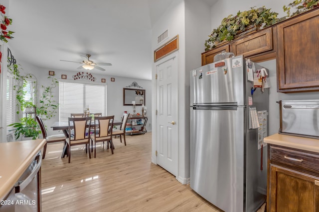 kitchen featuring stainless steel fridge, light hardwood / wood-style flooring, and ceiling fan