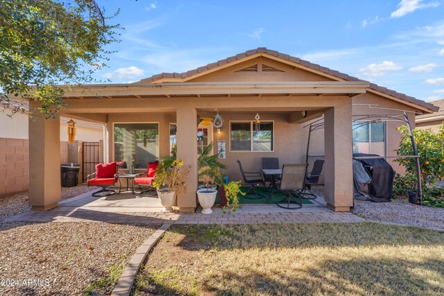 rear view of house featuring a patio and a lawn