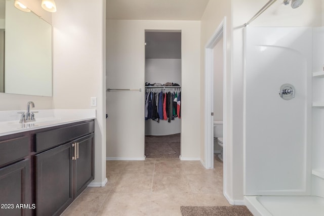 bathroom with vanity, tile patterned flooring, toilet, and a shower