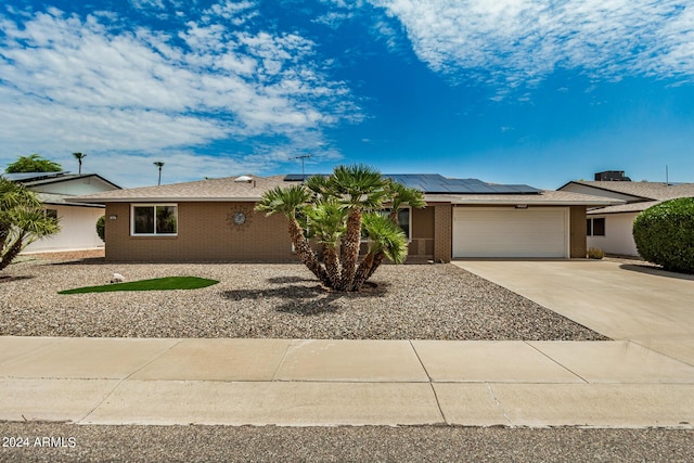 single story home featuring a garage and solar panels