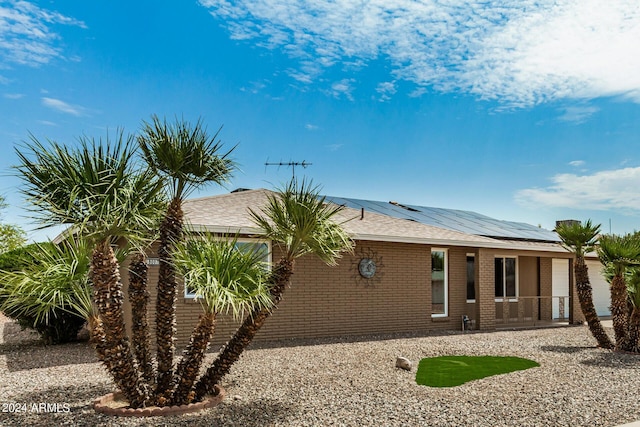 back of property featuring solar panels