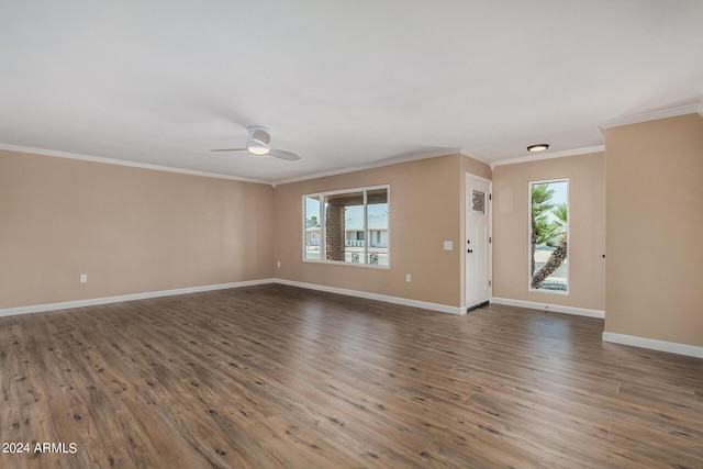 unfurnished living room featuring dark hardwood / wood-style flooring, crown molding, and ceiling fan