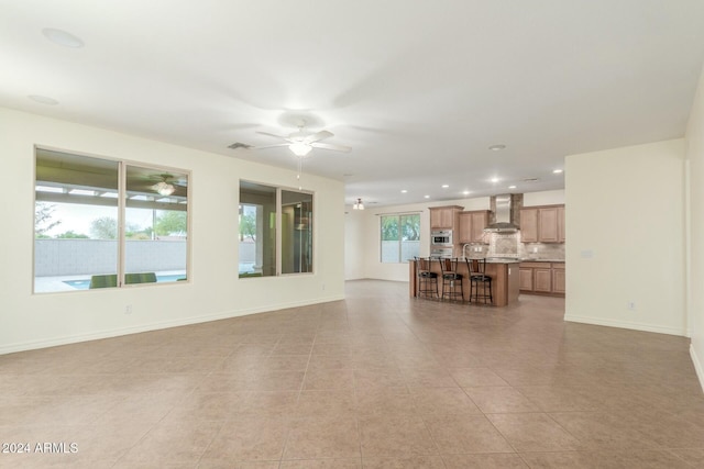 unfurnished living room with ceiling fan and light tile patterned floors