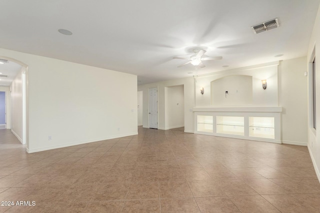 tiled spare room featuring ceiling fan