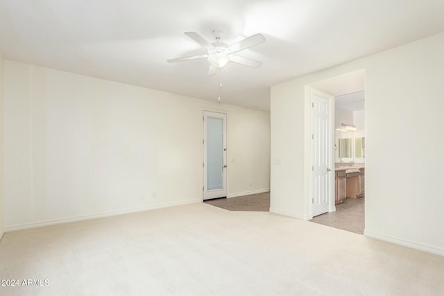 empty room featuring ceiling fan and light colored carpet