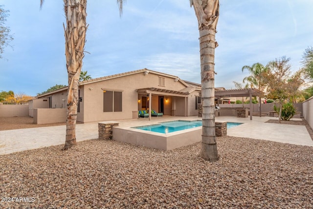 rear view of house featuring a fenced in pool and a patio area