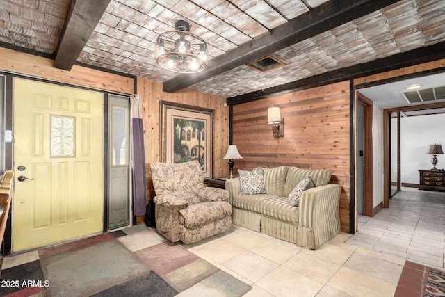 tiled living room featuring beam ceiling and wooden walls