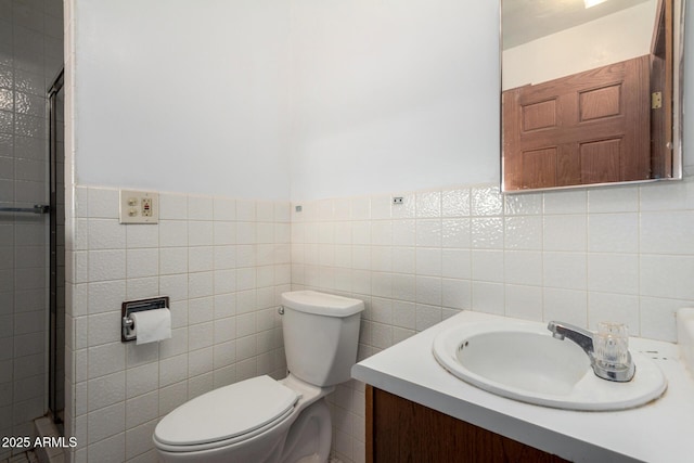 bathroom with vanity, tile walls, and toilet