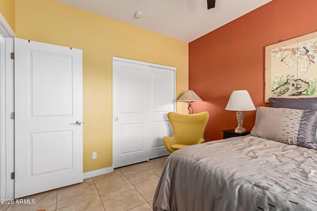 tiled bedroom with ceiling fan and a closet