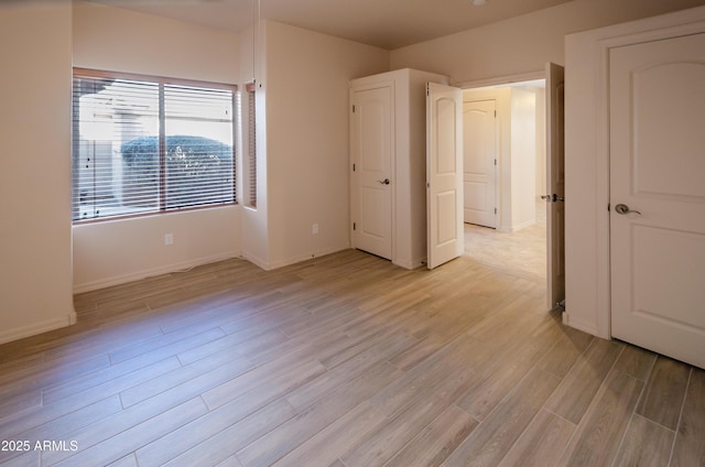 unfurnished bedroom with light wood-style floors and baseboards