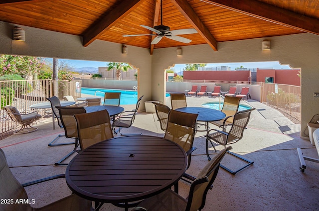 view of patio featuring a ceiling fan, a fenced in pool, and fence