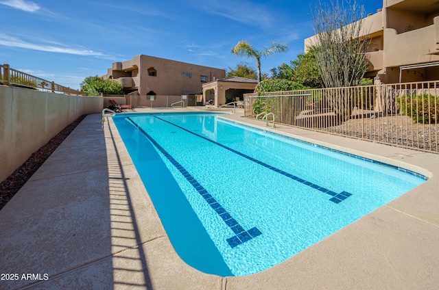 pool with a patio area and fence