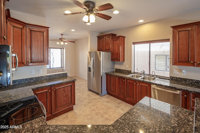 kitchen with ceiling fan, recessed lighting, stainless steel appliances, a sink, and dark stone countertops