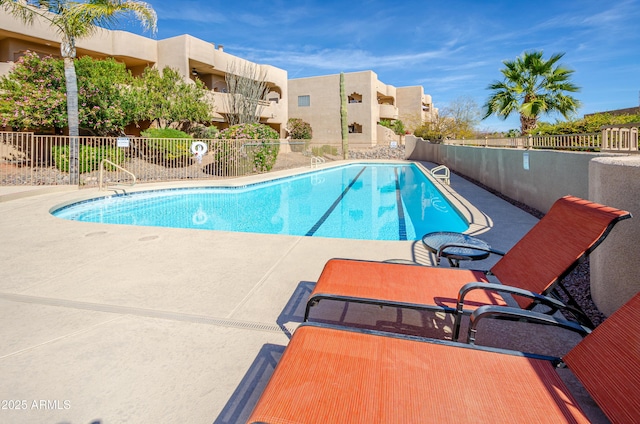 pool featuring fence and a patio