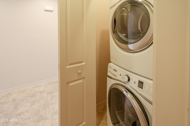 laundry room featuring laundry area, baseboards, and stacked washer / dryer